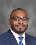 Aaron Smith  is wearing a business suit with a tie